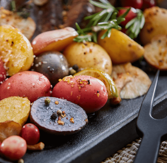 Variety of small potatoes on an iron skillet – Recipes by By Season