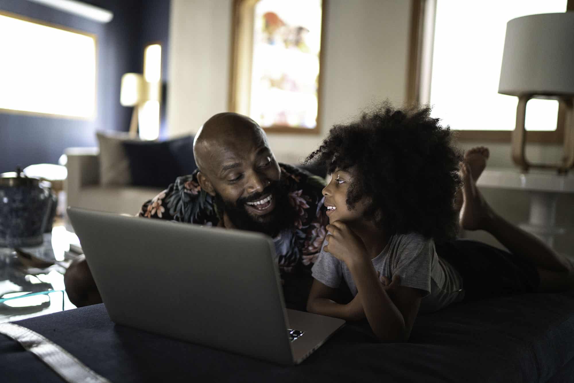 Single father watching movie on a laptop with his daughter