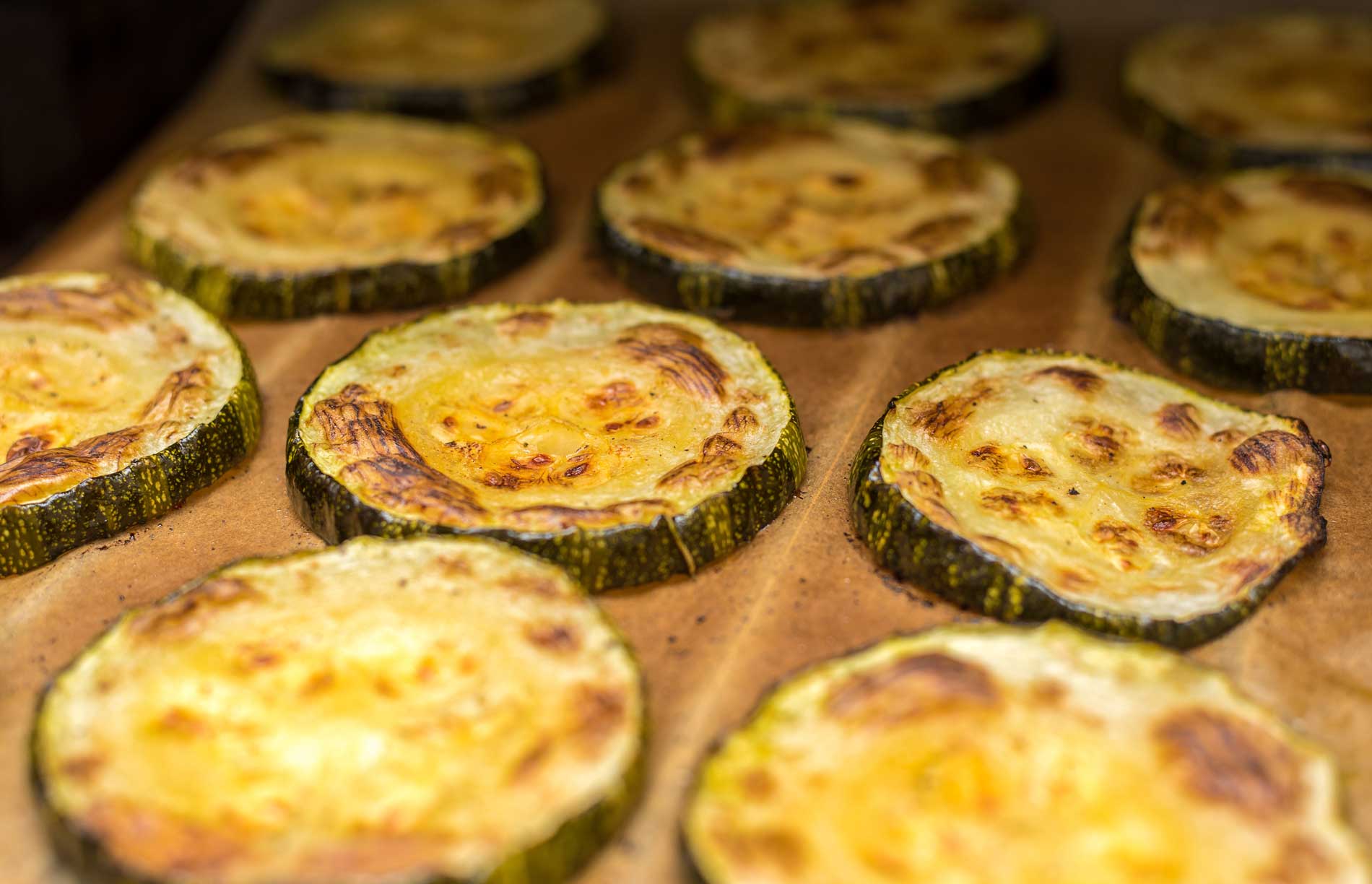 Baked zucchini slices on parchment paper.